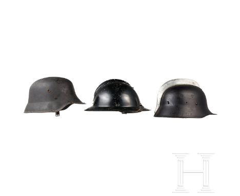 Fünf internationale Feuerwehr- oder Zivilschutzhelme, 1940er - 1960er Jahre  Stahlhelm, deutsch, um 1945, mit schwarz nachlac
