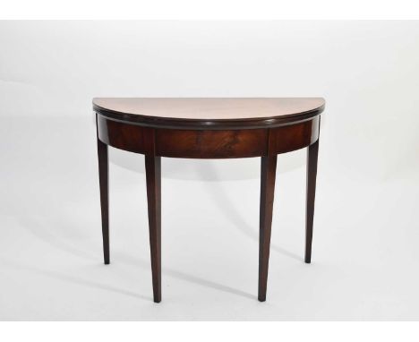 A George III demi-lune mahogany tea table, inlaid with ebony and boxwood stringing, raised on tapering square legs, faded, 91