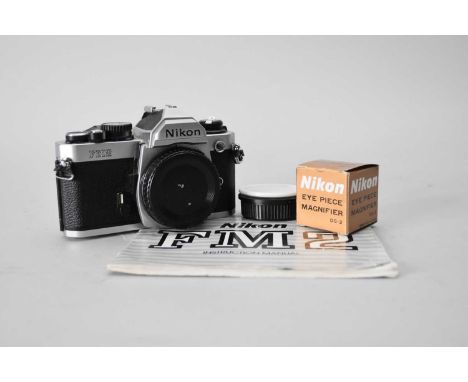 A Nikon FM2 35mm SLR camera body, with original instruction manual and a soft carry case, together with a boxed Nikon eyepiec