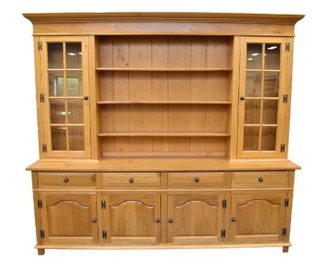 A large light oak dresser cabinet by Venables Brothers, Cheswardine, the ogee cornice and plain frieze above a panelled back 