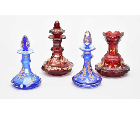 Four Bohemian scent bottles, one lacking stopperlate 19th centurythe ruby and blue glass bottles decorated with gilded flower