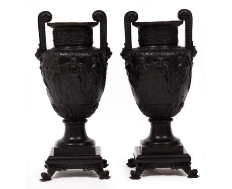 A PAIR OF CAST BRONZE URNS of classical form with handles and processing figures, later drilled for use as table lamps 20cm w