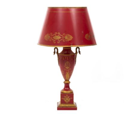 A RED AND PARCEL GILT PAINTED TOLEWARE TABLE LAMP in the French manner, with swan head finials either side of a classical urn