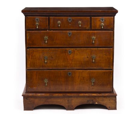 AN 18TH CENTURY WALNUT CHEST OF THREE SHORT AND THREE LONG DRAWERS with brass drop handles and raised on a plinth with bracke