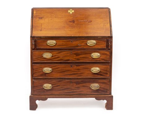 A 19TH CENTURY MAHOGANY BUREAU the fall front opening to reveal oak drawers and pigeon holes above four long graduated drawer