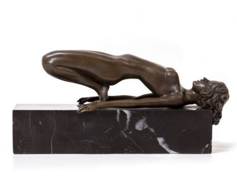 A BRONZE FIGURE OF A FEMALE NUDE in reclining position, on a black marble plinth base, 11.5cm high overall