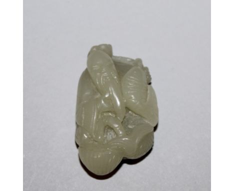 A 19TH/20TH CENTURY CHINESE CELADON JADE-LIKE PENDANT, carved in the form of a fisherman holding a carp, 2.25in high.