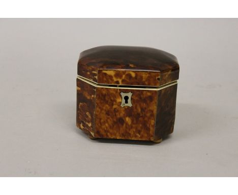 A SMALL REGENCY TORTOISESHELL TEA CADDY AND COVER with cut off corners, ivory frame and supported on four boxwood feet.