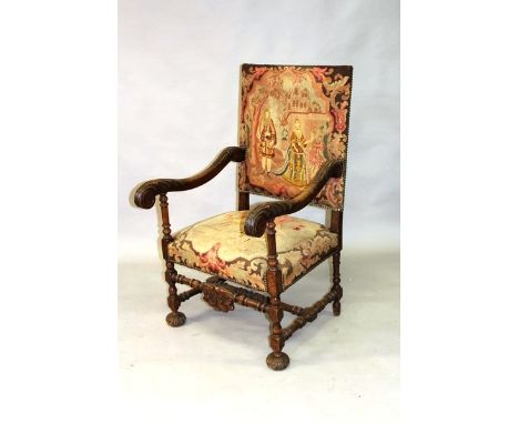 A 17TH CENTURY STYLE CARVED ARMCHAIR with tapestry back and seat.