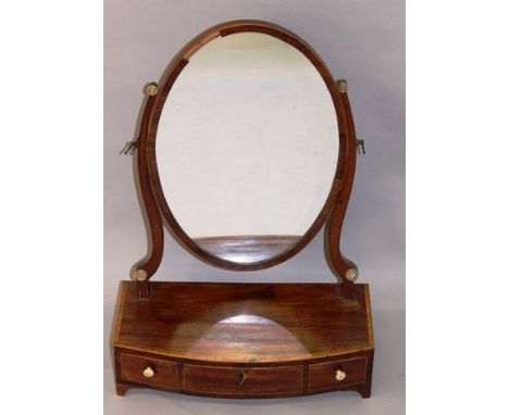 A GEORGIAN MAHOGANY BOWFRONTED TOILET MIRROR with oval mirror, curving supports, bowfronted base with three drawers, ivory ha