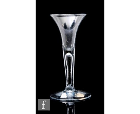 An 18th Century drinking glass circa 1740, the drawn trumpet bowl above a solid plain stem with internal tear, raised to a do