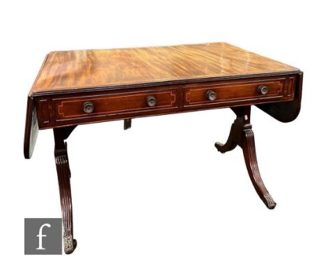 A Regency rosewood crossbanded mahogany sofa table, fitted with two drawers, circular handles on splayed reeded legs supporte