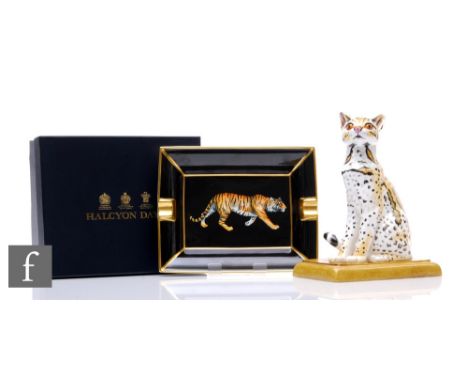 A Halcyon Days ceramic animal figure 'Ocelot Cub', modelled seated on marbled cushion slab, height 20.5cm, together with a 'M
