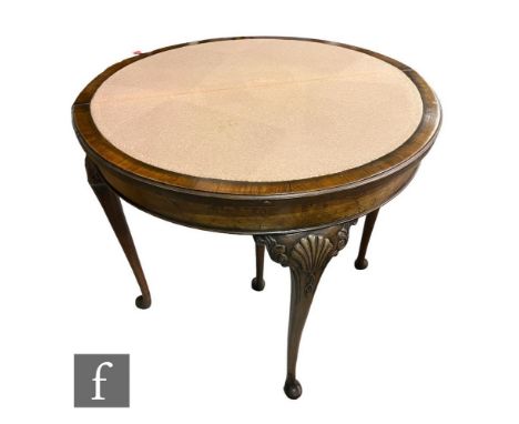 A 1930s demi-lune fold over burr walnut card table, the carved edge over a baize interior on cabriole legs terminating in pad