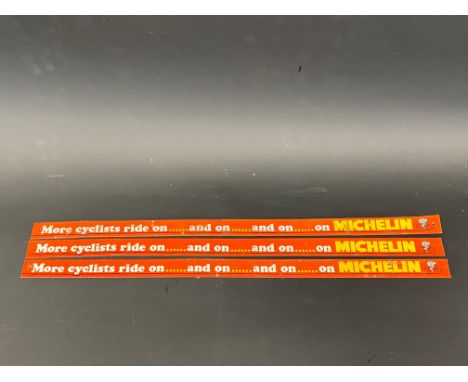 Three narrow Michelin tin advertising shelf strips 'More cyclists ride on...and on...'.