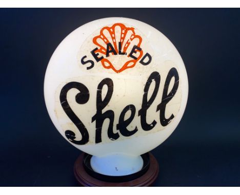 A reproduction petrol pump globe with Shell decal to one side and Pratts to the other.