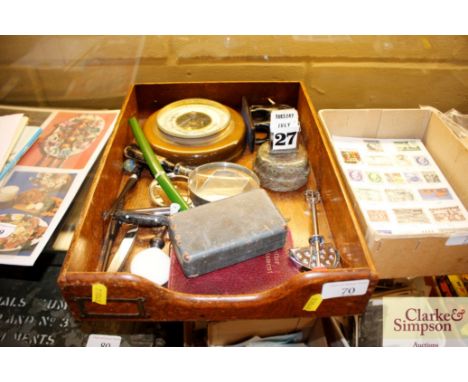 A tray of miscellaneous items to include a calendar, an aneroid barometer magnifying glasses etc. 