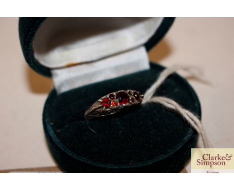 A silver and red stone set dress ring