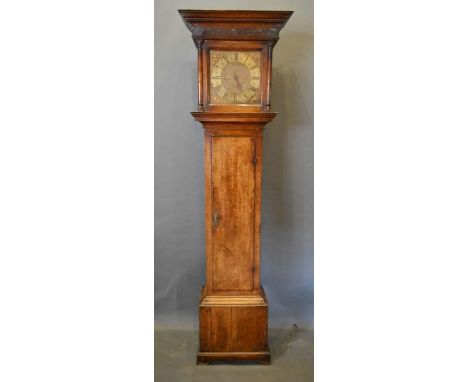 An Oak Longcase Clock, the square hood with half pilasters above a rectangular door, the plinth with bracket feet, the brass 