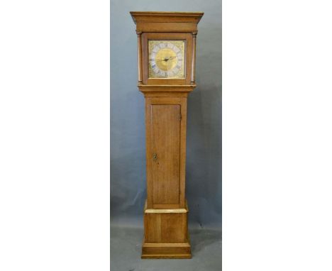 An Oak Longcase Clock, the square hood with half pilasters above a rectangular door on conforming plinth base, the brass dial