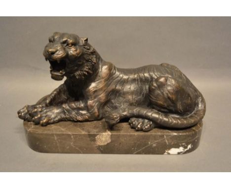 A Patinated Bronze Model in the Form of a Tiger upon rectangular variegated marble plinth, 31cm long 