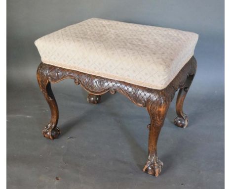 A 19th Century Rectangular Stool with an upholstered seat above a carved frieze raised upon cabriole legs with ball and claw 