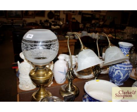 A modern brass oil lamp and shade and a pair of table lamps