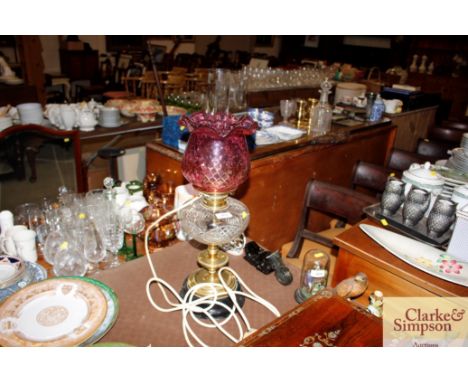 A brass and cut glass table oil lamp with dimpled ruby glass shade converted to electricity 