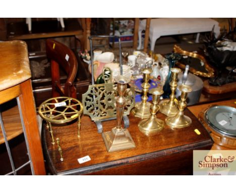 An antique brass and steel hearth trivet; two pairs of brass candlesticks; a singular brass candlestick and a hearth stand AF