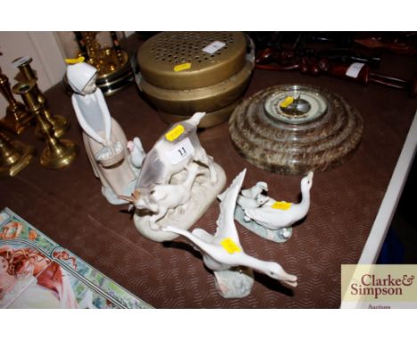 Two Lladro ware goose groups; a Royal Copenhagen group of goats; and a Nao ware figure of a girl collecting eggs