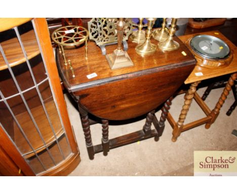 A 1930's oak gate leg tea table on barleytwist supports 