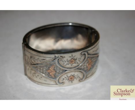 A white metal and yellow metal inlaid snap bangle