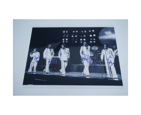 Black and white autographed photo of The Whispers, an iconic R&amp;B vocal group, signed by multiple members. The image captu