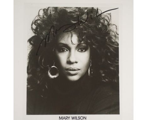 A black and white autographed photograph of Mary Wilson, a founding member of The Supremes. The image features a striking por