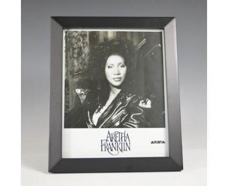 A striking Aretha Franklin signed promotional photograph, featuring the Queen of Soul in a classic black-and-white portrait. 