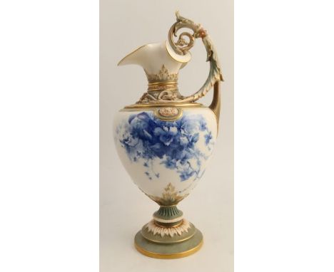 A Royal Worcester ewer, with green neck and pedestal foot, the body decorated with blue flowers to a white ground, height 14i