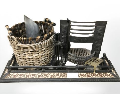 A tiled cast iron fire curb, fire grate, basket, brass footman, companion set, two wicker baskets etc 