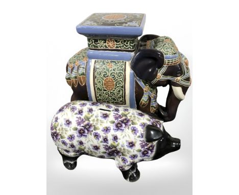 A ceramic elephant plant stand and a contemporary money box in the form of a pig.