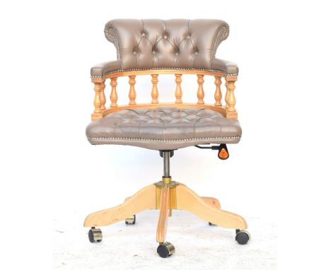 A contemporary Italian grey vinyl and beech captains swivel office chair, button upholstered, in a 19th century form, each 62