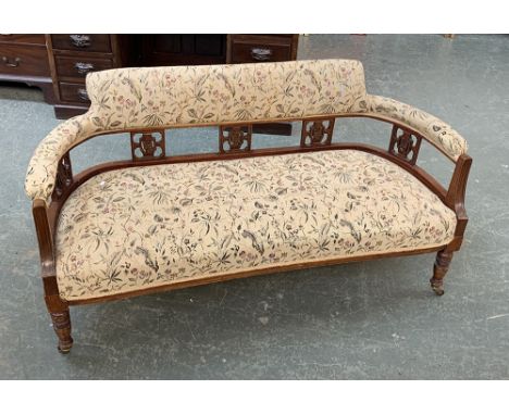 A small Victorian walnut framed sofa, upholstered rail on pierced splats, stuffover seat, turned legs and ceramic casters, 13