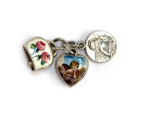 A silver and enamel puffy heart charm depicting Raphael's cherub, 1cmW; together with a similar silver charm and a silver bel