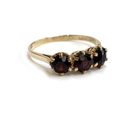 A 9ct gold garnet three stone ring, size R, 2.4g, in an Art Deco bakelite ring box 