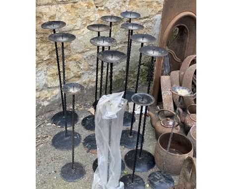 Fourteen metal candlestick holders, the taller 75cmH 