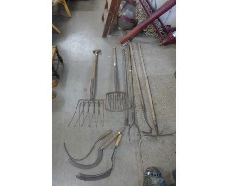 Assorted vintage garden tools, including a hay fork, rake, potato shovel, etc. 