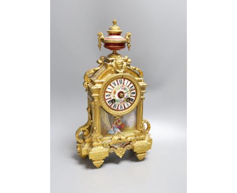 A French gilt spelter mantel clock, with porcelain figurative cartouche and enamelled dial,37 cms high.