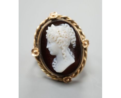 A yellow metal and oval hardstone cameo set dress ring, carved with the bust of a lady to dexter, size M, gross weight 7 gram