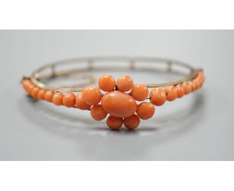 A gold plated and coral bead cluster set hinged bangle.