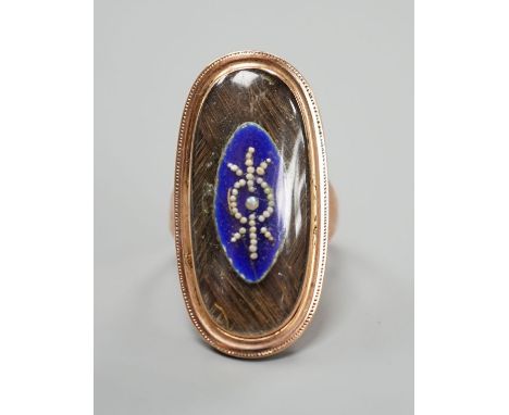 A 19th century yellow metal, blue enamel, seed pearl and plaited hair set oval mourning ring, size M, gross weight 7.2 grams.