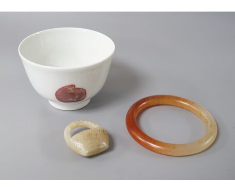 A Chinese porcelain teabowl with ‘fruit’ decoration, an agate bangle and a similar ‘basket’ carving.