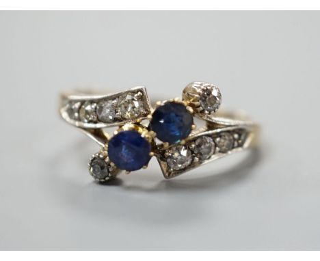 An 18ct, sapphire and diamond cluster set crossover ring, size S/T, gross 3.7 grams.